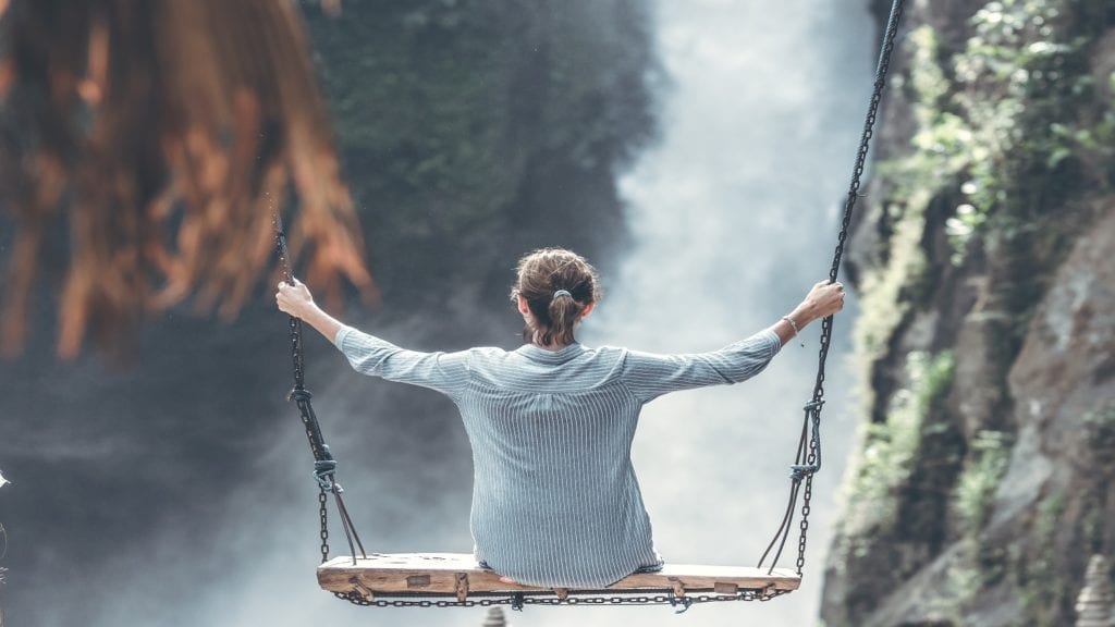 Beautiful woman swings near waterfall in the jungle of Bali island, Indonesia. Beautiful woman swings near waterfall in the jungle of Bali island.